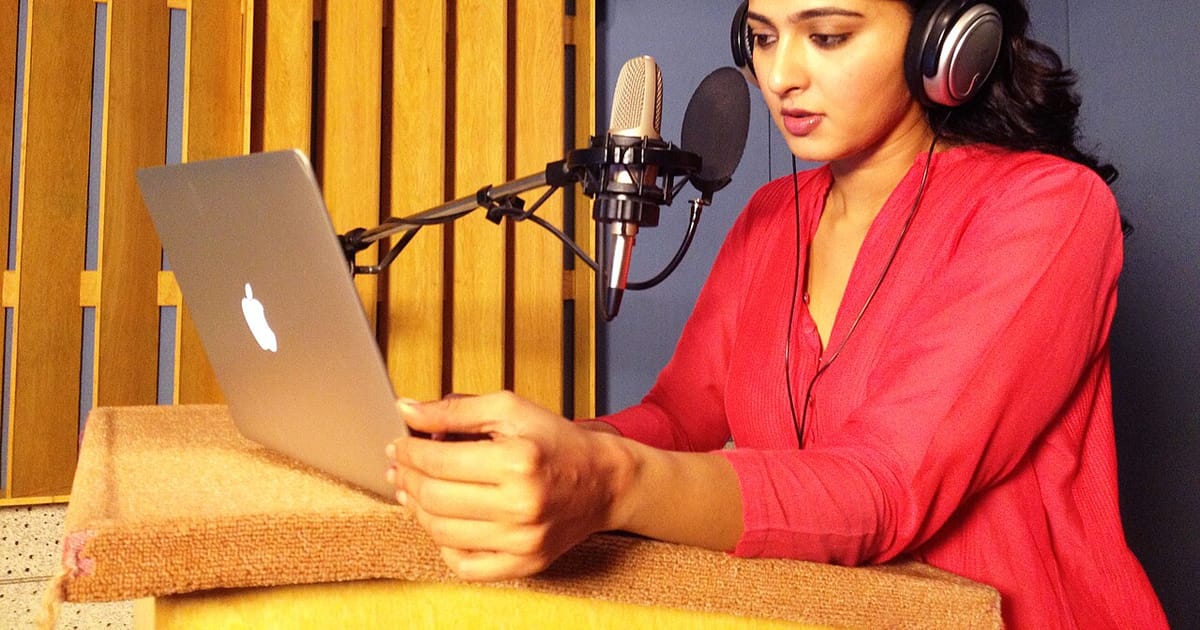 A person recording audio with a studio microphone and headphones